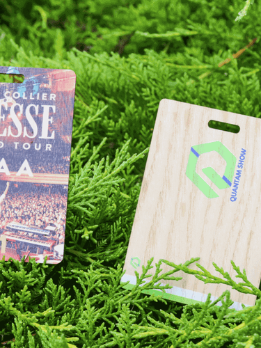Custom Printed Sustainable Event Passes for Jacob Collier and The Quantam Show pictured on top of greenery