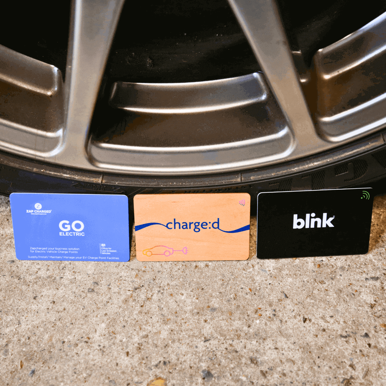 Custom Printed Sustainable EV Charging Cards pictured against a car wheel