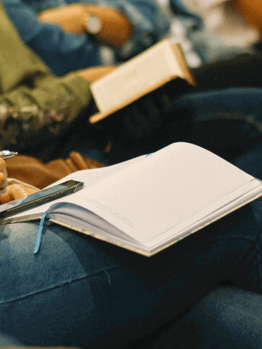 Person sat with an open textbook at an event